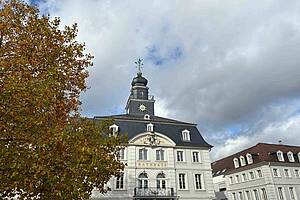 Das Alte Rathaus von außen mit einem herbstlichen Baum im Vordergrund