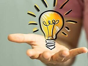 Hand mit einer gezeichneten leuchtenden Glühbirne