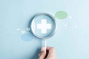 Eine Lupe mit einem Kreuz in der Mitte, rechts und links von der Lupe sind zwei Sprechblasen abgebildet